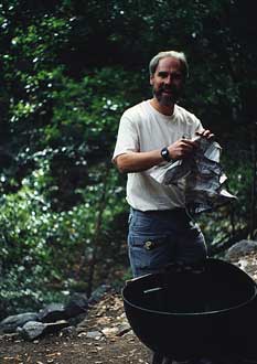 C hris preparing charcoal grill -- by Ned